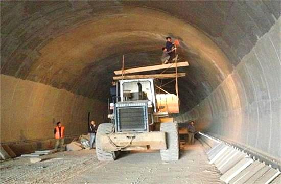 隨著我國公路建設規(guī)模的日益擴大，公路隧道建設取得了很大的發(fā)展,公路隧道具有斷面大，地質(zhì)條件和施工技術復雜等特點，加之設計時對地質(zhì)條件的認識不夠全面準確，通車后存在的隧道老化、運營管理和維護等方面的原因，致使我國公路隧道的病害問題十分嚴重，隧道襯砌背后的空洞問題就是其一，由此引起的拱頂上鼓及襯砌內(nèi)緣壓裂、掉塊的現(xiàn)象嚴重影響到公路隧道的使用壽命。因此加強對隧道襯砌背后空洞的檢測判斷和處理，是隧道工程病害處理的重要一環(huán)。 一、檢查目的和必要性 目的：隧道拱部襯砌出現(xiàn)空洞剝落掉塊直接危及行車安全，但襯砌內(nèi)部病害隱蔽，無法通過肉眼發(fā)現(xiàn)，通過人工敲擊可有效發(fā)現(xiàn)襯砌內(nèi)部空洞等隱患，并對無損檢測資料有針對性的進行驗證。 必要性：通過隧道找部襯砌人工敲擊檢查?？蓪Υ蟛糠止安坎『霸绨l(fā)現(xiàn)并進行整治，從而降低運營期間拱部襯砌剝落掉塊的風險。 二、檢查時機和范圍 1、檢查時機 隧道二次襯砌貫通后，接觸網(wǎng)安裝前為最佳檢查時機，接觸網(wǎng)安裝后通電前次之，通電后則須停電 。 2、接觸網(wǎng)安裝前、后敲擊檢查的區(qū)別 接觸網(wǎng)安裝前后，敲擊方法、車輛、工具基本相同。主要區(qū)別： （1）接觸網(wǎng)作業(yè)車檢查平臺，升起高度或檢查架搭設高度不同，接觸網(wǎng)安裝前接觸網(wǎng)作業(yè)車檢查平臺升起高度或檢查架搭設高度距拱頂3米左右，拱頂至拱腰均易于敲擊，接觸網(wǎng)安裝后接觸網(wǎng)作業(yè)車檢查平臺升起高度，或檢查架搭設高度距離拱頂至少4米。 （2）檢查槌長度不同。接觸網(wǎng)安裝前檢查槌長度為2米左右，接觸網(wǎng)安裝后檢查槌長度為2.5米至4.6米。 3、檢查范圍 當使用供電檢查車或軌道車平板上搭檢查架檢查時，從拱頂中心線至起拱線半幅為一次敲擊檢查范圍，當使用檢查架檢查時，從線路左側(cè)起拱線至線路右側(cè)起拱線全幅為一次敲擊檢查范圍。 圖片描述(最多50字) 三、檢查前準備工作 1、車輛：接觸網(wǎng)檢查車，平板車搭檢查架，在鋼軌或側(cè)溝蓋板上推進檢查架，以雙線隧道，軌頂至拱頂9米為例，且檢查平臺距接觸網(wǎng)立柱等侵限物體保持10至20厘米間距。 （1）采用接觸網(wǎng)檢查車檢查無接觸網(wǎng)時，檢查平臺高度以距拱頂3米為宜，檢查平臺橫向放置，有接觸網(wǎng)時，檢查平臺高度以距拱頂5米為宜，檢查平臺縱向放置，需要時再旋轉(zhuǎn)到橫向位置。 （2）平板車搭檢查架，鋼軌上安裝檢查架或側(cè)向水溝蓋板和兩線間底板頂搭設檢查架，無接觸網(wǎng)時，檢查平臺高度以距拱頂距離3米為宜，檢查平臺橫向?qū)挾瓤蛇_9米，有接觸網(wǎng)時，檢查平臺高度距離拱頂4米為宜，兩線間平臺需下凹0.5米，檢查平臺橫向?qū)挾瓤蛇_9.5米。 圖片描述(最多50字) 2、工具：大型工具有：接觸網(wǎng)檢查車、軌道車（含平板車）、檢查架（根據(jù)凈空定制）；小型工具有：手提式強光手電筒、頭部礦燈、檢查槌（空心鋼管直徑30mm，一端焊接一根尖頭鋼筋一端焊接一根平頭鋼筋，長度2至4.6米不等），卷尺、塞尺、鋼直尺、噴漆、桶裝油漆、漆桿（4.5米長竹竿一端綁扎油漆刷）、檢查梯、對講機、照相機、手套、安全帶、安全帽、防護衣、護目鏡、口罩、記錄本、黑水筆等。 3、人員：作業(yè)小組由8人組成（使用接觸網(wǎng)檢查車或軌道車時需1人持對講機指揮車輛），檢查車分工為：3人持檢查槌（敲擊半幅拱頂線路正上方拱腰，線路側(cè)方拱腰至起拱線），2人聽敲擊音并標記，1人記錄并拍照，1人指揮并負責安全檢查和提示，檢查架分工為：4人持檢查槌敲擊拱頂、拱腰，2人聽敲擊音標記并負責指揮及安全檢查提示，2人記錄并拍照。 四、敲擊檢查程序 1、開窗安排：提前一天申請檢查天窗，天窗時間本線封鎖不少于8小時，鄰線限速每小時20公里，根據(jù)批準的天窗計劃，駐站聯(lián)絡員在《行車設備登記簿》內(nèi)登記，列車高度員下達調(diào)度命令；施工負責人接到調(diào)度命令后按調(diào)度命令憑證發(fā)車；檢查車到指定地點后，立即設置防護體系。在距離檢查地點20米處現(xiàn)場防護員設置移動停車信號彈（燈），在距離施工地點800米兩端防護員設置顯示停車手信號；鄰線防護需設置移動減速信號牌和減速地點標。天窗作業(yè)計劃結(jié)束前機車返回申請停靠點。駐站聯(lián)絡員與現(xiàn)場防護員在執(zhí)行防護任務時，應佩戴標志攜帶通信設備，現(xiàn)場防護員還應攜帶必要的防護用品；隨時掌握現(xiàn)場和列車運行情況。發(fā)現(xiàn)異常情況及時通知車站值班員和施工負責人。駐站聯(lián)絡員應與現(xiàn)場防護員時刻保持聯(lián)系。 圖片描述(最多50字) 2、敲擊作業(yè)：車輛行駛速度控制在每小時5公里以內(nèi)，檢查架推進速度控制在每小時1公里以內(nèi)，行進過程中進行敲擊，憑敲擊聲音辨別是否存在空洞，聲音異常時停車仔細敲擊確認空洞范圍，施工縫、混凝土修補、蜂窩、混凝土表面有雜物（如鋼筋頭、注漿管等）、施工冷縫、止水帶外露、防水板外露、閉環(huán)裂紋、變形外鼓等重點處所均停車進行仔細敲擊檢查。 3、照明配置、照度、范圍：BAD305手提式防爆探照燈2臺，BAD212微型手持防爆調(diào)光工作燈2臺，LED722B充電頭燈2臺，照度不低于250勒克斯，照明可視距度10m。 4、敲擊人員自我防護注意事項：（1）作業(yè)前將勞動防護用品穿戴整齊‘（2）攀爬腳手架時，要站穩(wěn)扶牢。登上檢查平臺后，須首先掛好安全帶和安裝欄桿扶手，工具應放置穩(wěn)固。（3）接觸網(wǎng)檢查車檢查平臺、檢查架移動前應通知作業(yè)人員停止作業(yè)，將工具擺放穩(wěn)固，人員蹲下扶牢，目視前進方向，機車指揮人員發(fā)現(xiàn)侵限物體要及時停車，拆除侵限物體。檢查架移動就位后，必須設好滾輪制動和斜撐后，方可作業(yè)。（4）檢查小組人員必須團結(jié)協(xié)作、聽從指揮，相互提醒安全注意事項，做到自控、互控。（5）人員站位要相對固定，避免檢查槌等工具碰傷人員。（6）清除襯砌掉塊時，應高聲提醒所有人員注意安全，下方無人時，方可進行作業(yè)。（7）鄰線來車時，須停止作業(yè)，小穩(wěn)扶牢，檢查工具不得侵限。 5、檢查架的組成：同槽鋼跑道、腳手架滾輪及抽動裝置、 鋼管立柱、鋼管橫撐、鋼管斜撐、十字卡、萬向卡、腳手板及鐵絲、欄桿及鎖口鋼筋、反光標等組成。 6、缺陷確認：敲擊聲音清脆，發(fā)出“鐺、鐺、鐺”的聲音說明襯砌混凝土比較密實，如果敲擊聲音沉悶出現(xiàn)“咚、咚、咚”的聲音，說明襯砌混凝土存在空洞，附帶檢查內(nèi)容包括襯砌掉塊、裂紋、滲漏水、露筋、鋼筋保護層厚度不足、蜂窩麻面、混凝土夾帶雜物等。 7、問題標記：發(fā)現(xiàn)問題停車采用紅油漆標記問題范圍，測量（估算）相關尺寸，將病害類型、尺寸等數(shù)據(jù)詳細記錄、拍照存檔，如在空洞外邊界標記面積范圍，在裂縫起終點位置用箭頭（箭頭朝向裂紋處）標記長度，箭頭旁標出裂紋寬度值，同時將問題類型、編號、里程用紅油漆在問題位置邊墻上進行標記，以便日后整改。標記形式“BLWKD-1-K493+179”，BLW指白力塢隧道，KD指拱部空洞，1指編號為1號，K493+179指空洞里程，若一個隧道有多處空洞，序號按里程從小到大排序，依次為1、2、3、4.......。 8、資料整理：為避免出現(xiàn)場檢查發(fā)現(xiàn)問題記憶模糊、相似問題相互混淆的情況，檢查小組每天須將當天檢查發(fā)現(xiàn)的問題，根據(jù)病害類型、部位、按靜態(tài)驗收報告格式進行梳理、統(tǒng)計，將照片編輯相應文字說明。